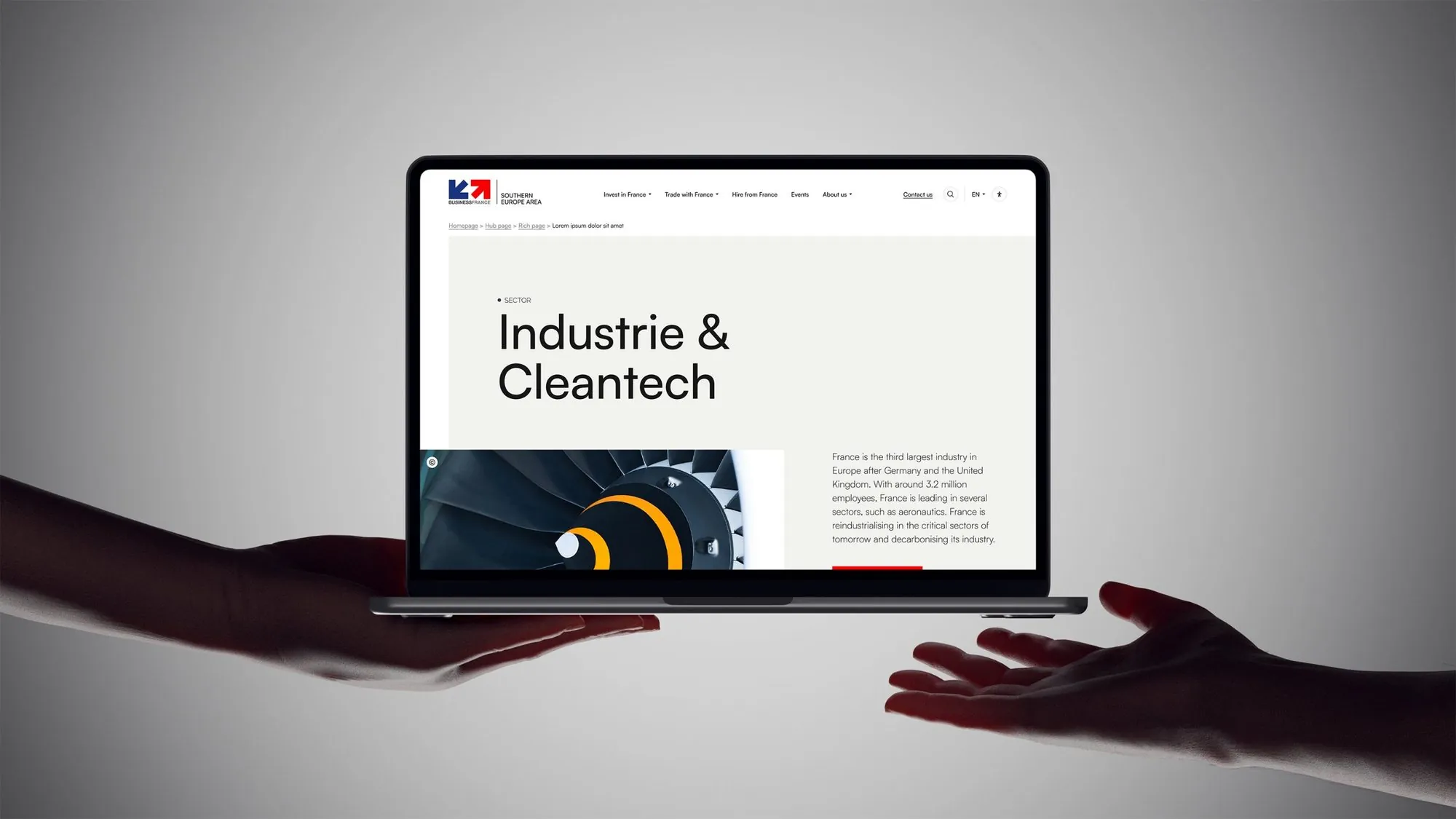 Page Industrie & Cleantech sur un ordinateur tenu à deux mains