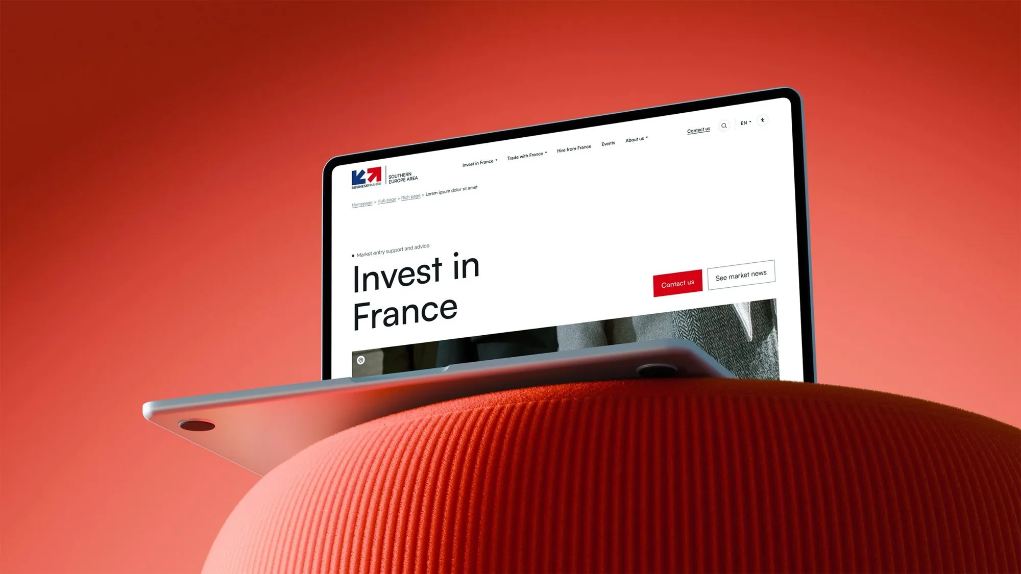 Page Invest in France sur un ordinateur posé sur un pouf rouge