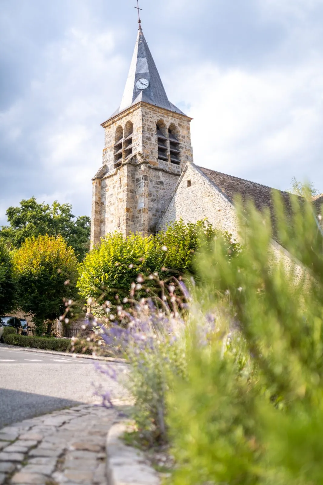 Clocher d’une église de village entouré de fleurs